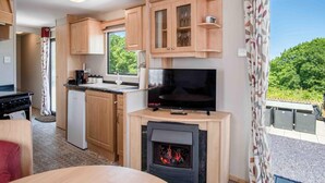 Eine kleine Küche mit Fernseher, Kamin und Essbereich.