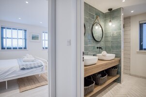 Un baño moderno con un espejo grande, dos lavamanos y un mueble de tocador de madera.