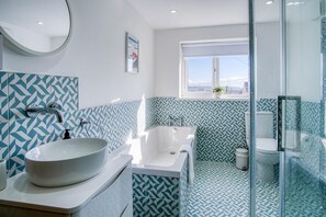 Een aparte badkuip en douche, handdoeken