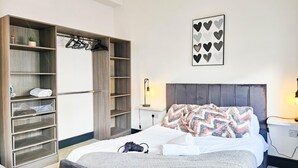Une chambre à coucher avec un lit, une armoire et une table de chevet.