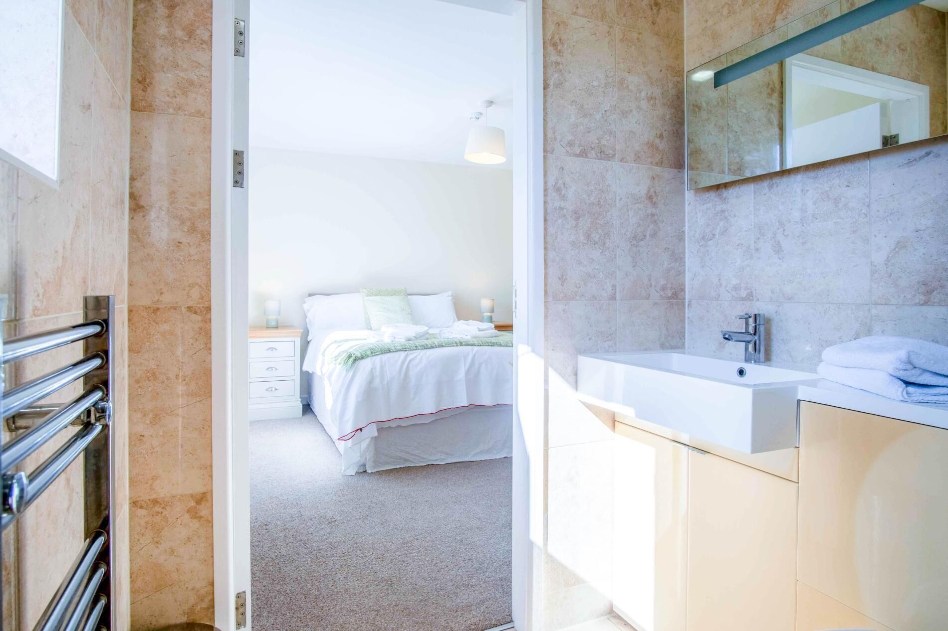 A modern bathroom with a large mirror, a white sink, and a bathtub.