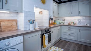 Une cuisine moderne avec des meubles de couleur bleu clair, un plan de travail en bois et un four encastré.