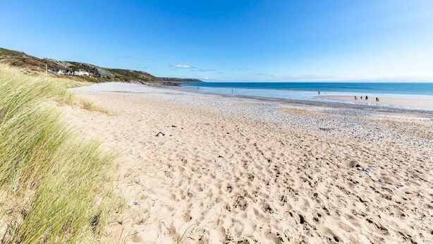 A sandy beach with a clear sky, some grass on the left, and a few people in the distance. - Fern Bank - 5 Bedroom House - Horton (Swansea)