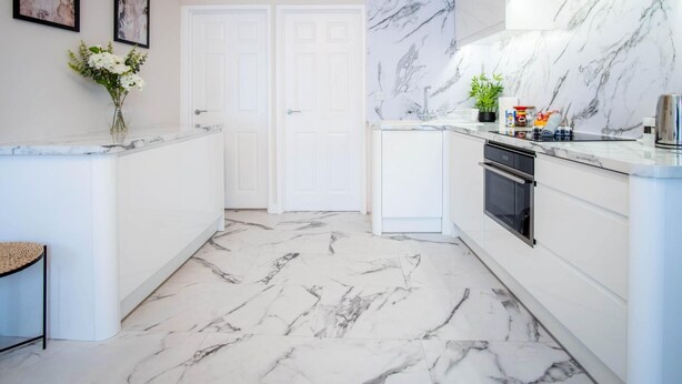 A modern kitchen with white cabinetry, marble flooring, and a built-in oven. - Station Road - 1 Bedroom Apt - Burry Port (Burry Port)