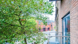 A modern building with a glass balcony overlooking a street.