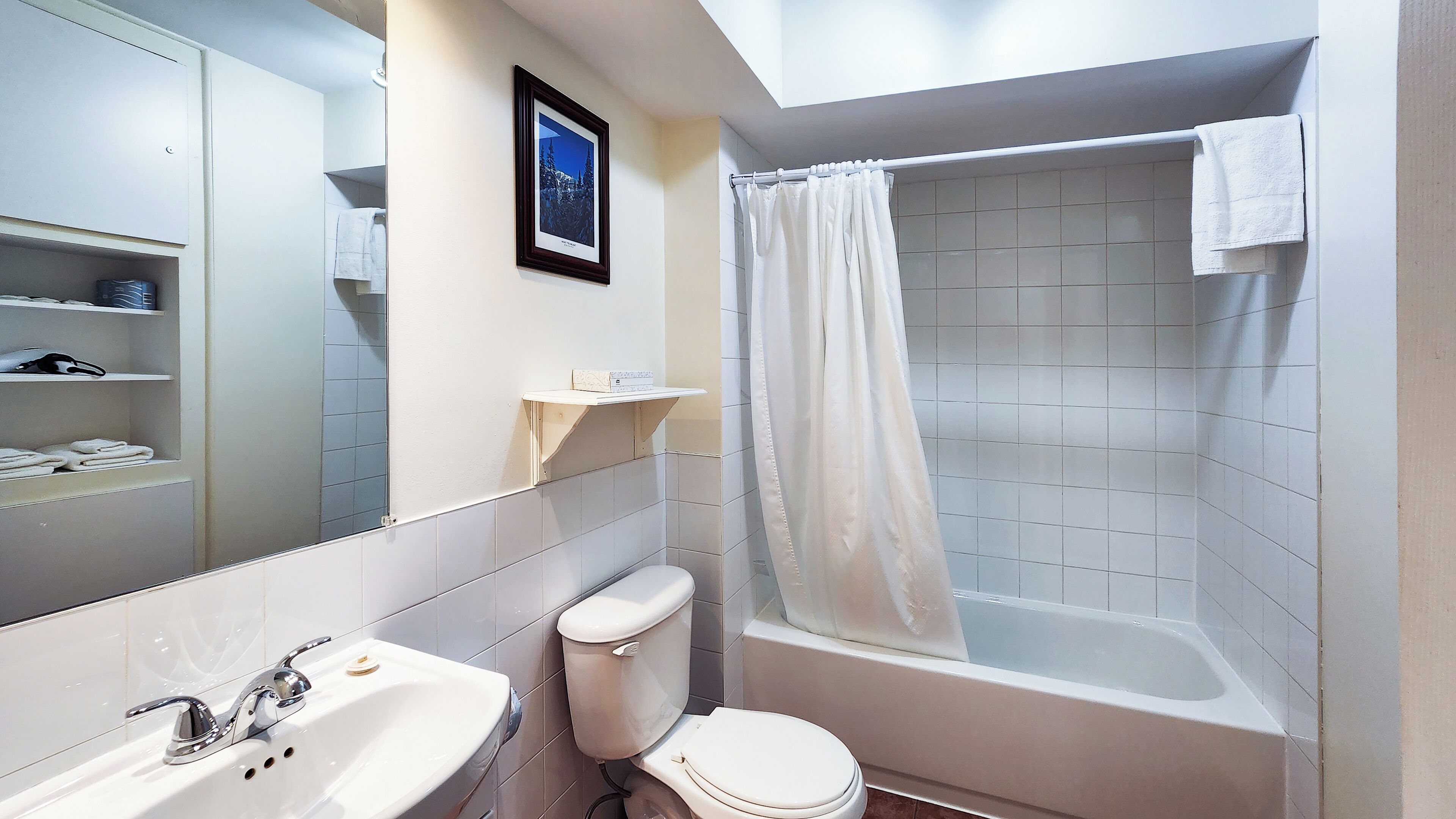 Een badkamer met toilet, wastafel en bad.