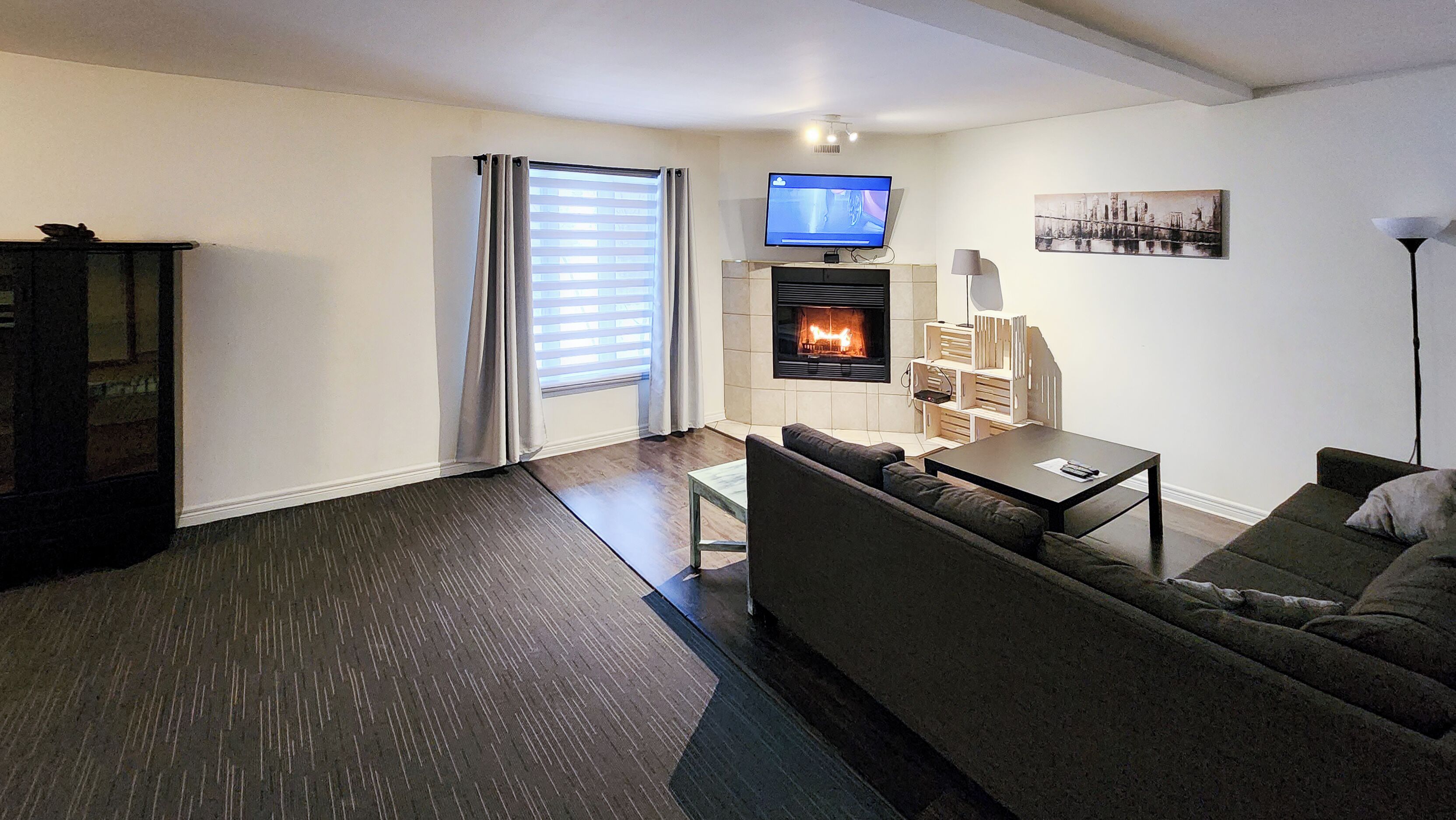 A modern living room with a fireplace, a television, and a sofa.