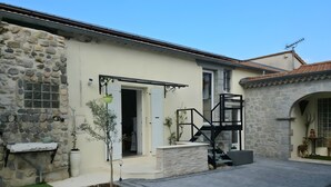 A stone building with a door, a small tree, and a staircase. - Gite Stéphanie l'Ephedra – Charming 3-Star Home with Pool in Sampzon (Sampzon)