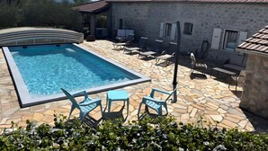 A swimming pool with stone tiles, lounge chairs, and a stone building with a tiled roof. - Gite Stéphanie l'Ephedra – Charming 3-Star Home with Pool in Sampzon (Sampzon)