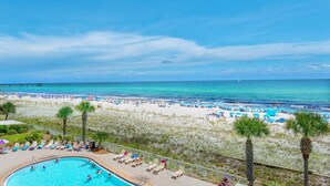 A beach resort with a swimming pool, beach chairs, and umbrellas. - Azure #112 (Fort Walton Beach)
