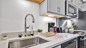 A modern kitchen with stainless steel appliances, a built-in dishwasher, and a large sink. - Near Hospitals & DT ~ Bright+Parking+W/D+Churchill (Louisville)