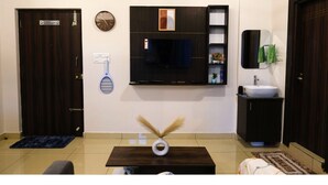 A modern bathroom with a large mirror, a sink, and a television mounted on the wall.