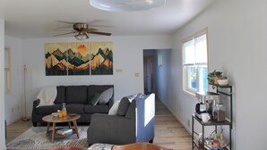 Ein Wohnzimmer mit Sofa, Couchtisch und Kunstwerk an der Wand.
