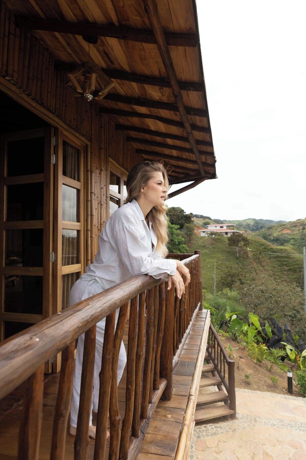 A wooden balcony with a railing, overlooking a hilly landscape. - Hotel Nuss (San Roque)