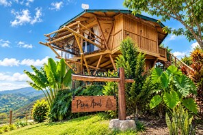 A wooden treehouse with a sign reading 'Pina Azul' surrounded by lush greenery. - Hotel Nuss (San Roque)
