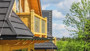 Une cabane en bois dotée d’une terrasse, de meubles d’extérieur et offrant une vue sur la verdure environnante.