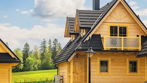 Une cabane en bois dotée d’un balcon, d’une piscine et d’une pelouse bien entretenue.