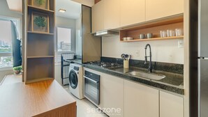 Una cucina moderna con lavatrice integrata, forno ed elettrodomestici in acciaio inossidabile.