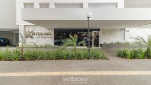 Un edificio moderno con un cartello che riporta 'ATEDRAL SKY ROOFTOP' e un'area di parcheggio.