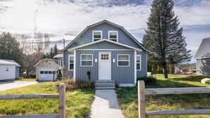 A two-story house with a front porch, a garage, and a pathway leading to the front door. - Convenient location for adventures in the Adirondacks! (Warrensburg)