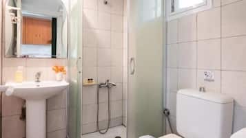 Vierpersoonskamer, uitzicht op de binnenplaats | Badkamer | Een douche, handdoeken, zeep, shampoo