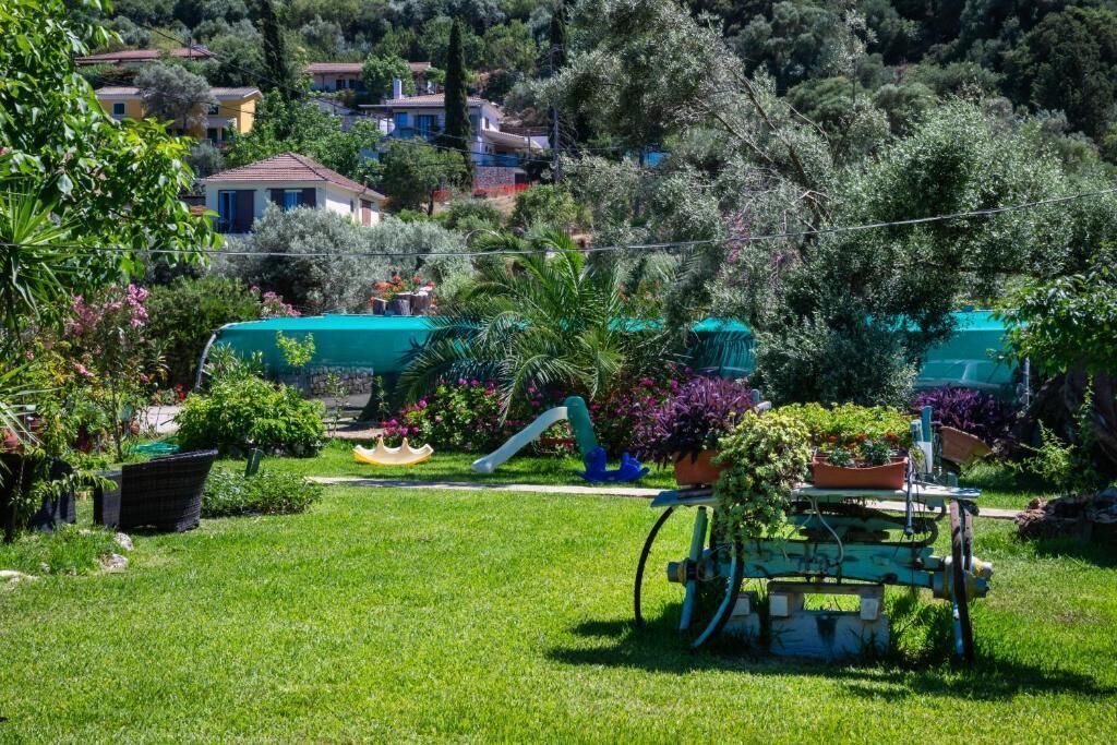 A lush garden with a variety of plants and a small play area.