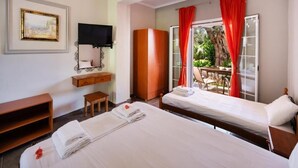 Une chambre d’hôtel avec deux lits, une télévision, une armoire et une petite table.