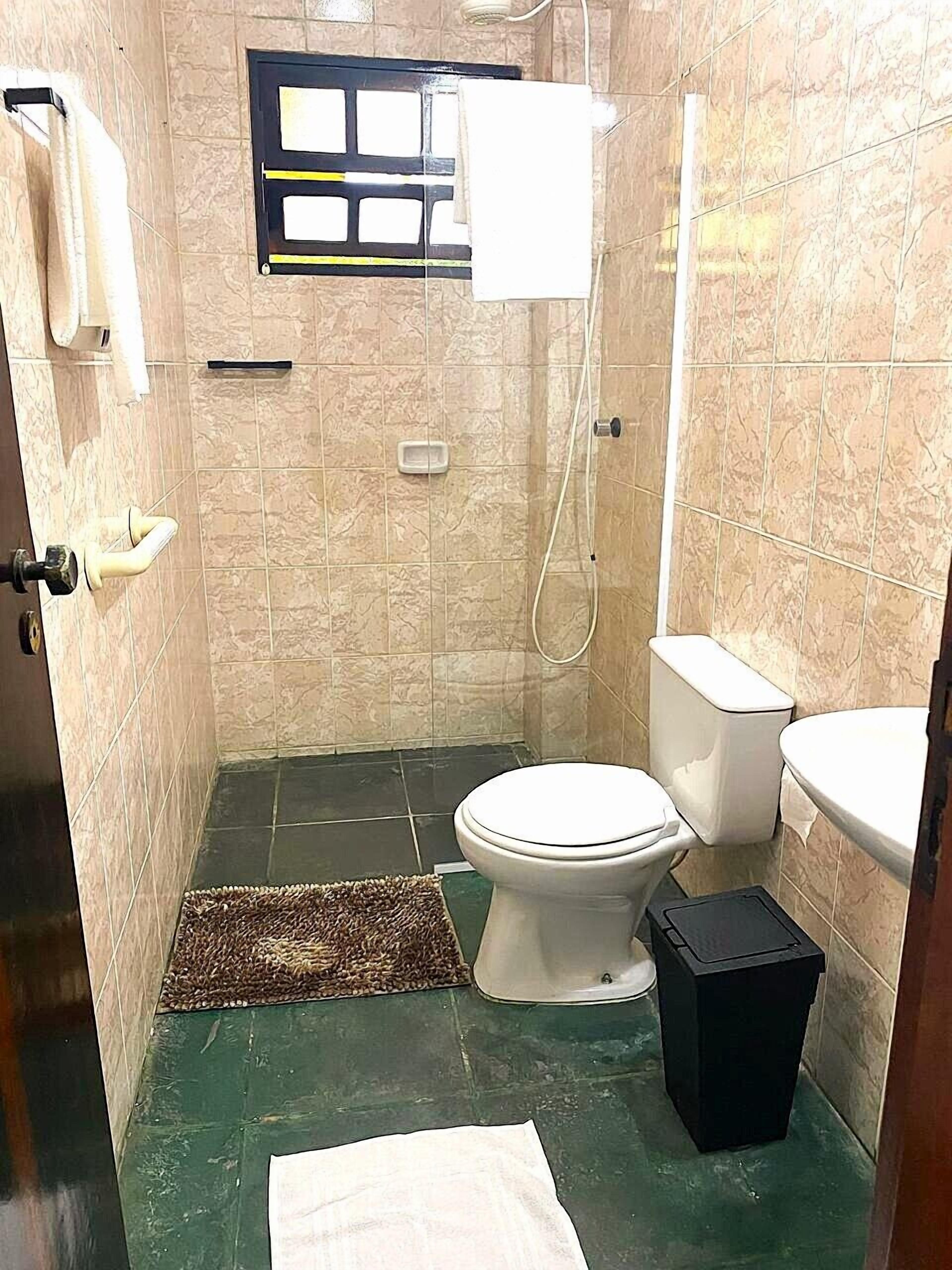 Un baño pequeño con inodoro, bidé y zona de ducha.