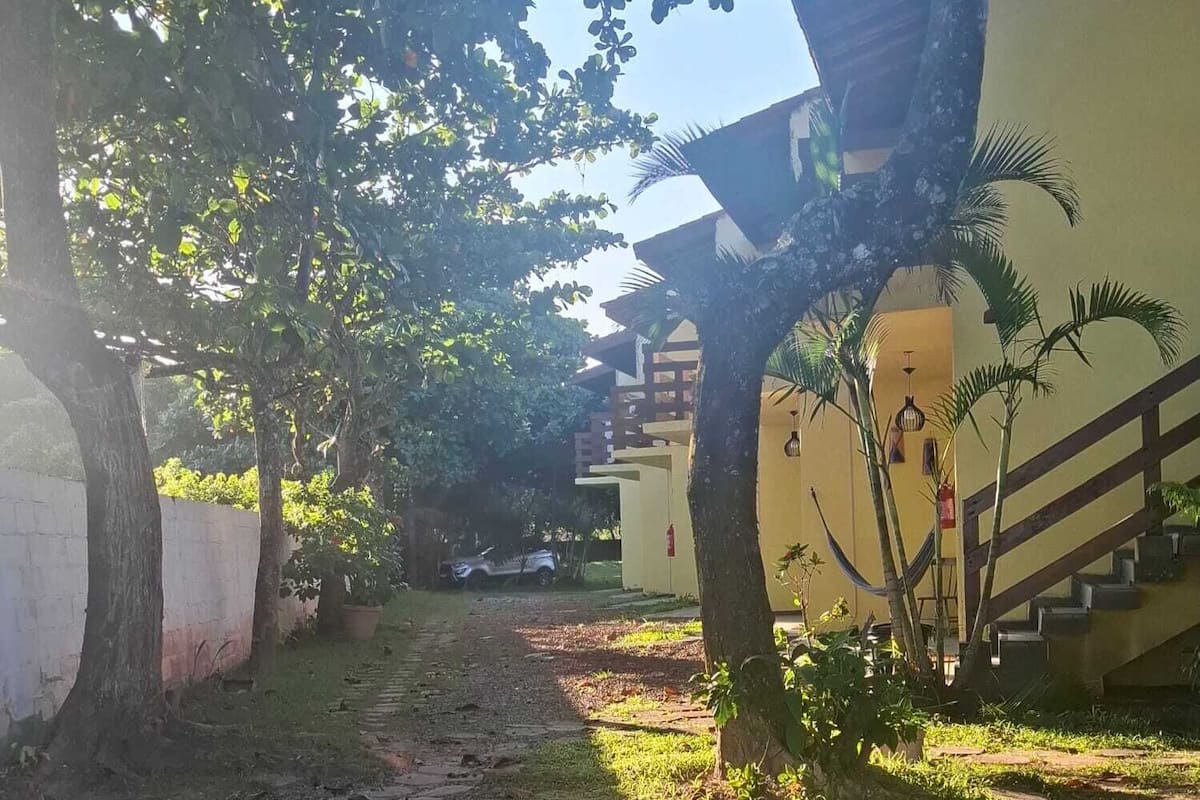 Un chemin menant à un bâtiment doté d’un escalier et d’un hamac.