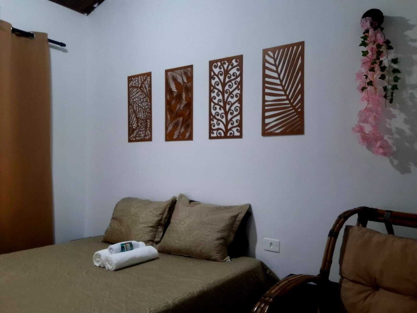 A hotel room with a bed, pillows, a chair, and decorative wall panels.