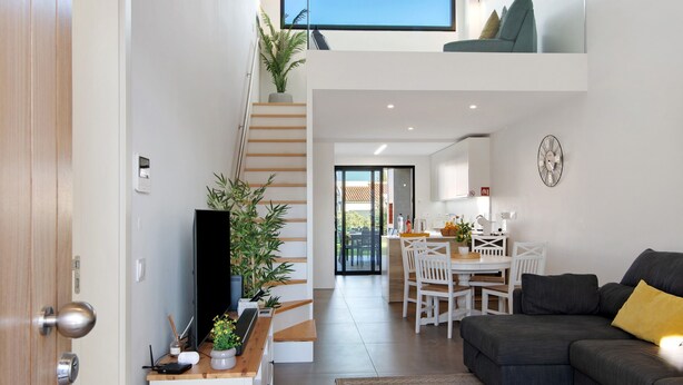 A modern interior with a staircase, a dining area, and a living room with a sofa. - Villa Soligolf - Vilamoura, Algarve (Villamoura)