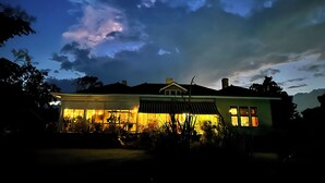 Een huis met een ruime veranda, een garage en een goed verlicht interieur.