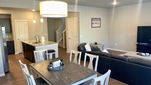 Um espaço moderno com sala de jantar, cozinha e área de estar.