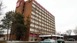 A multi-story hotel with a red and white facade, featuring a prominent 'Ramada' sign. - Albany Retreat- Free Breakfast & Parking Included (Albany)