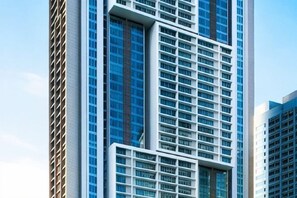 Un immeuble moderne de grande hauteur, doté d’une façade à motifs géométriques et de grandes fenêtres.