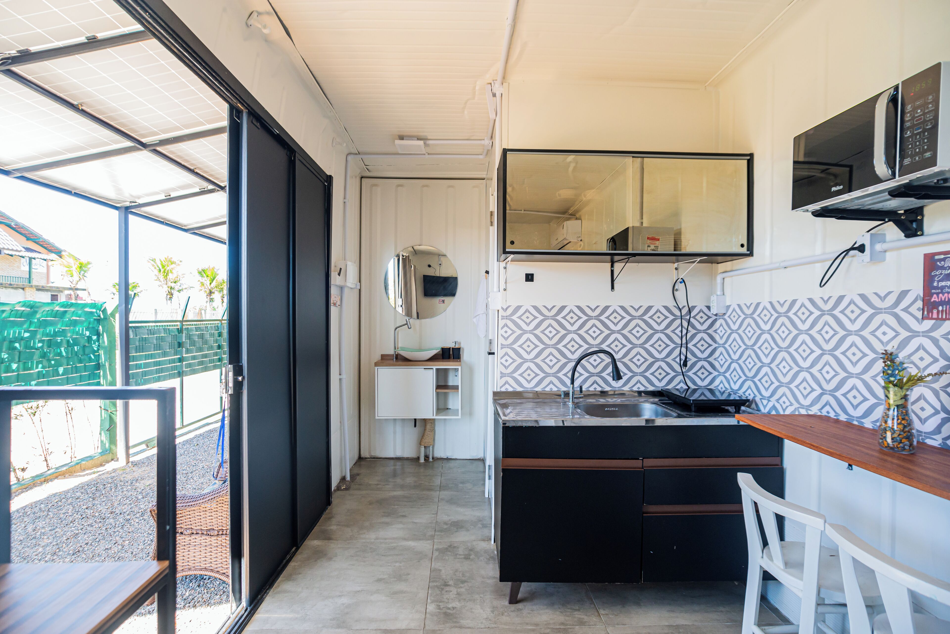 A compact kitchen with a sink, a microwave, and a small countertop.