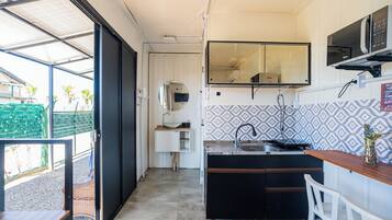 A compact kitchen with a sink, a microwave, and a small countertop.