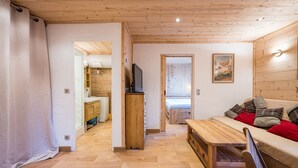 Ein Holzinterieur mit einer Couch, einem Holztisch und einem Fernseher.