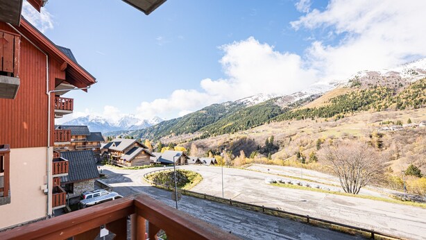 A mountain view with a wooden building, a parking area, and a clear sky. - Apartment 'Vacation Rental' with Mountain View and Balcony (Saint François Longchamp)