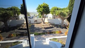 A staircase leading to a courtyard with a view of the sea, surrounded by potted plants and a white wall. - Paradise Homes Lanzarote (Nazaret)