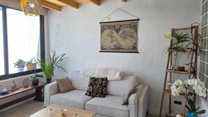 A cozy living room with a checkered sofa, a wooden coffee table, and a world map on the wall. - Paradise Homes Lanzarote (Nazaret)