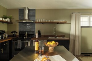 A modern kitchen with a central island, stainless steel appliances, and a variety of kitchenware. - The Long Shot ~ NuLu, Mini Golf, Hot Tub, Fire Pit, BBQ (Louisville)