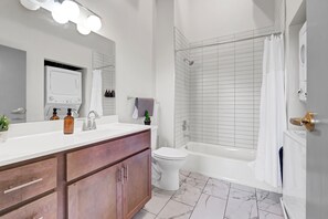 A modern bathroom with a vanity, toilet, and bathtub. - Near Hospitals & DT ~ Nice+Parking+W/D+YUM Center (Louisville)