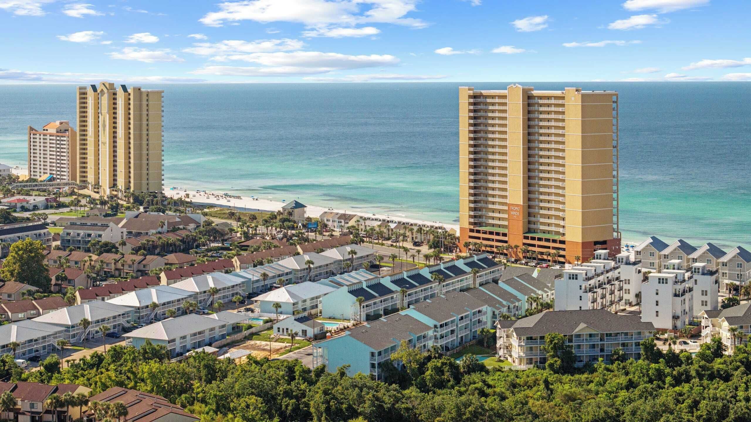 Eine Küstenregion mit Hochhäusern, Strand und einem Poolkomplex.