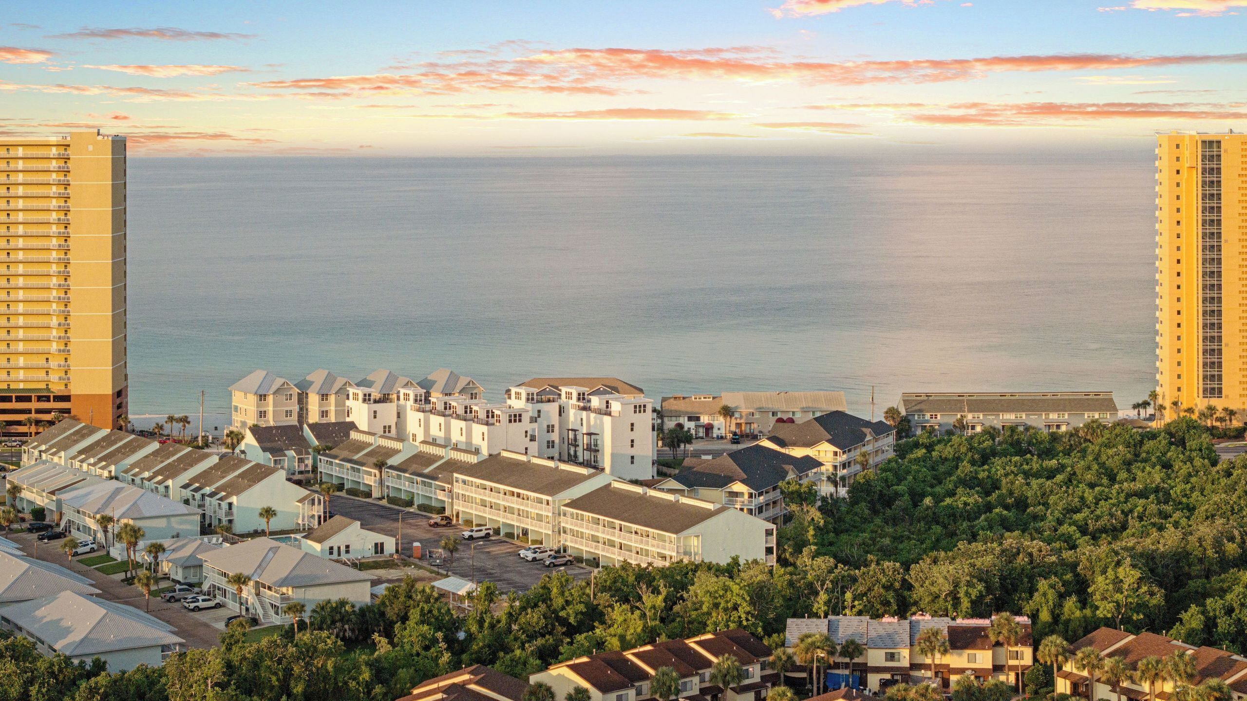 Una zona residenziale lungo la costa, con edifici a più piani, un porto turistico e una vista libera sull'oceano.