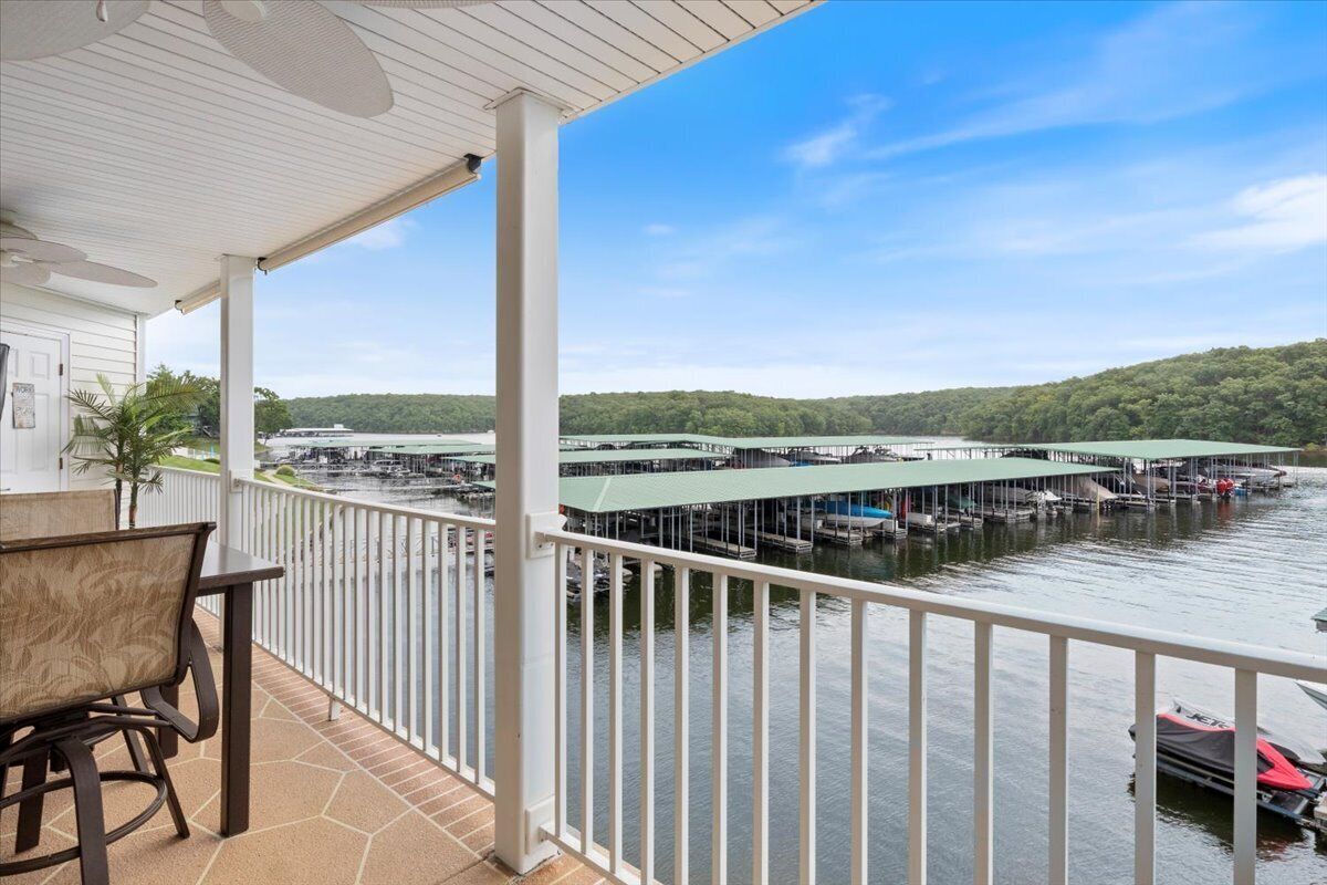 A covered balcony with a view of a marina and docked boats.