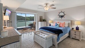 A bedroom with a bed, bedside tables, a ceiling fan, a large window, and a balcony. - Lakeview Condo, Pools, Patio With Grill, Near PB2 Launch (Osage Beach)