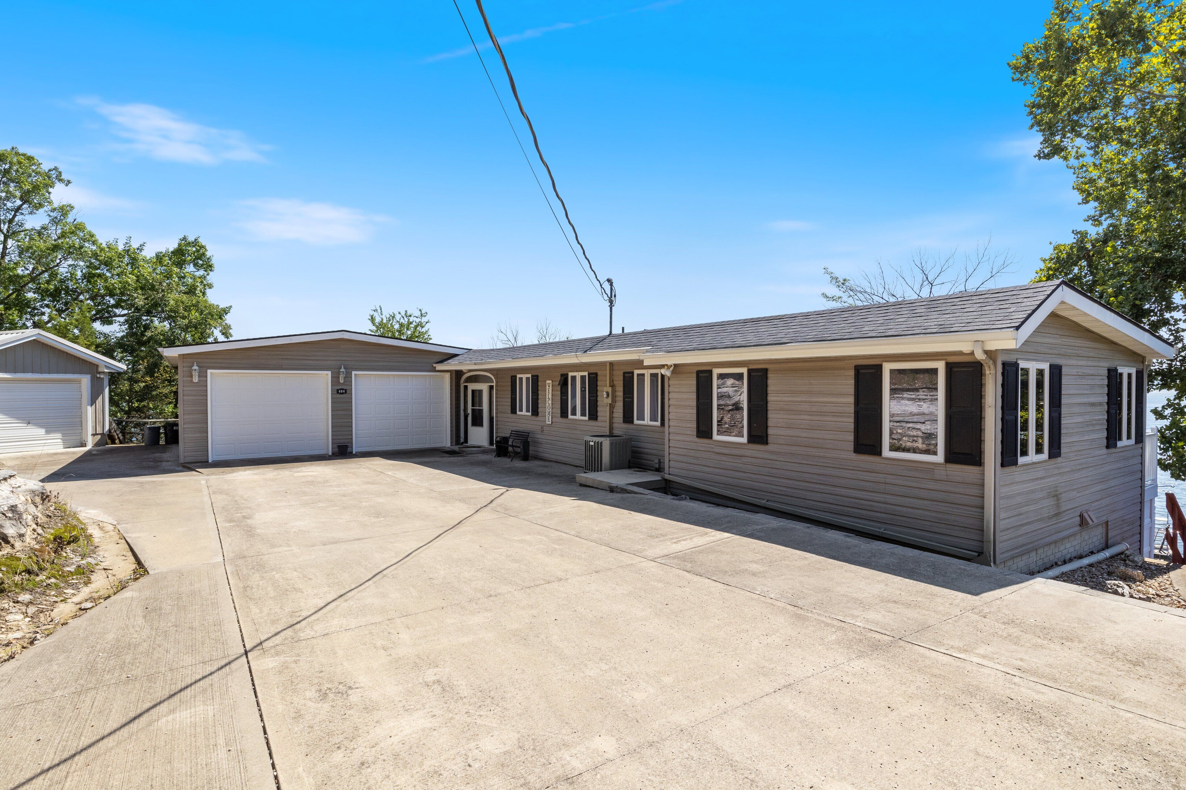 A single-story mobile home with a garage, a covered patio, and a small front porch.
