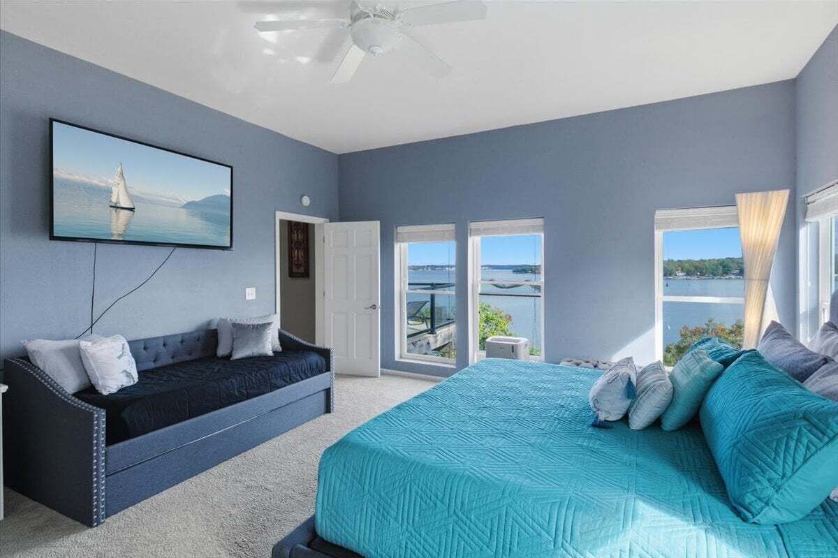 Una camera da letto con un letto, un divano, una TV e vista sull'esterno.