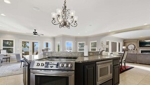 A spacious kitchen with a large island, built-in oven, and granite countertops.